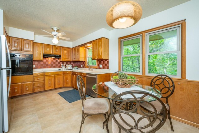 108 56th St, Des Moines, IA 50312 - kitchen with black appliances, tasteful backsplash, a textured ceiling, light countertops, and brown cabinetry