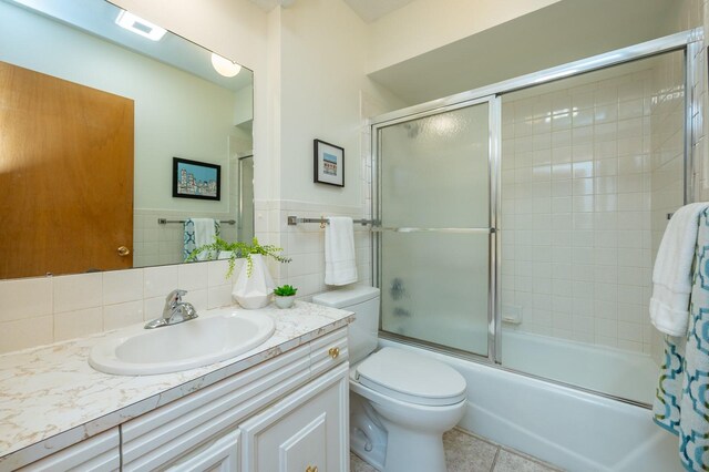 108 56th St, Des Moines, IA 50312 - bathroom featuring vanity, enclosed tub / shower combo, tile walls, and tile patterned floors
