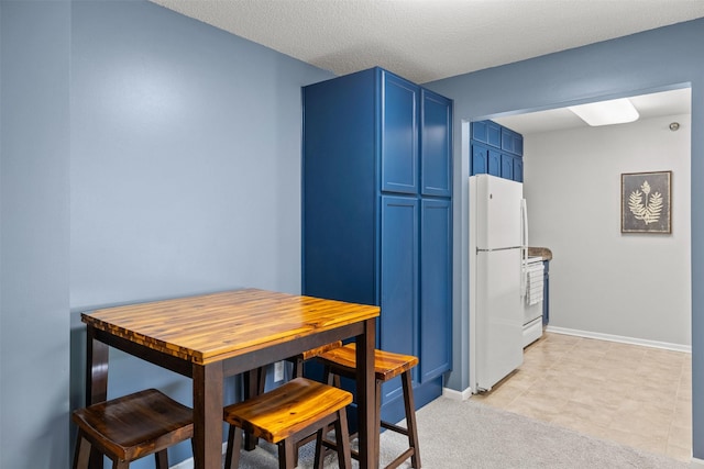 2128 NW 156th St Unit 31, Clive, IA 50325 - kitchen featuring blue cabinetry, freestanding refrigerator, and stainless steel electric stove
