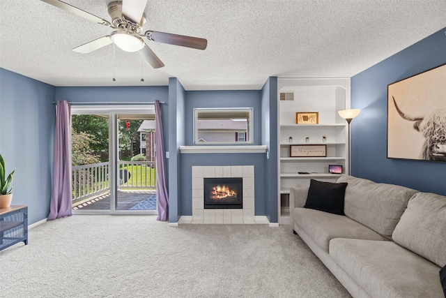 2128 NW 156th St Unit 31, Clive, IA 50325 - living area with carpet floors, a textured ceiling, a tile fireplace, ceiling fan, and built in features