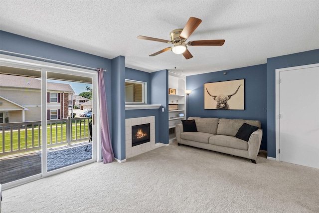 2128 NW 156th St Unit 31, Clive, IA 50325 - living room featuring carpet, a tile fireplace, ceiling fan, and a textured ceiling