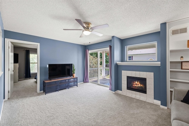 2128 NW 156th St Unit 31, Clive, IA 50325 - unfurnished living room featuring carpet, a ceiling fan, a fireplace, and a textured ceiling