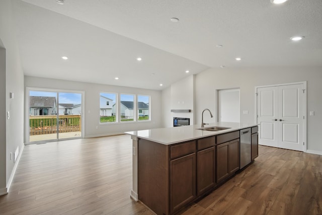 1819 Tuscany Dr SE, Altoona, IA 50009 - kitchen with light wood-type flooring, light countertops, vaulted ceiling, a center island with sink, and open floor plan