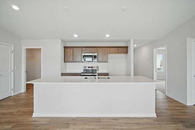 1819 Tuscany Dr SE, Altoona, IA 50009 - kitchen featuring stainless steel appliances, recessed lighting, a center island with sink, backsplash, and light countertops