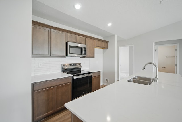 1819 Tuscany Dr SE, Altoona, IA 50009 - kitchen featuring stainless steel appliances, light countertops, tasteful backsplash, recessed lighting, and light wood-style flooring