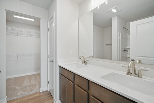 1819 Tuscany Dr SE, Altoona, IA 50009 - full bathroom with wood finished floors, double vanity, and a spacious closet