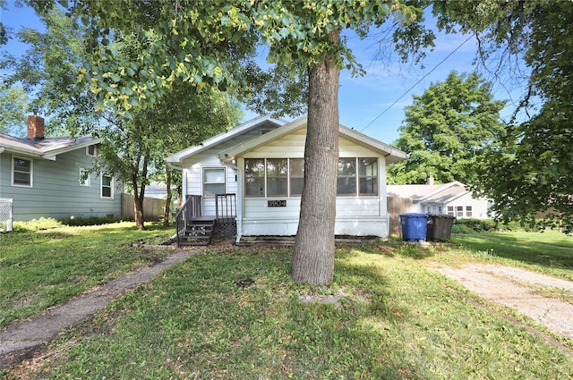 3904 3rd St, Des Moines, IA 50313 - view of front of property featuring a sunroom and a front lawn