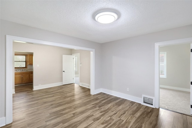 3904 3rd St, Des Moines, IA 50313 - spare room featuring wood finished floors and a textured ceiling