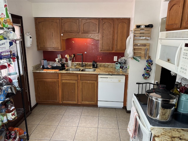 1105 Bundy St, Des Moines, IA 50315 - kitchen with white appliances, brown cabinetry, light tile patterned flooring, and light stone counters