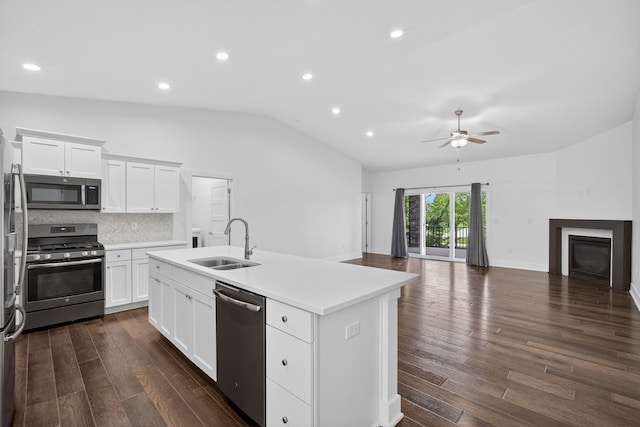 9322 Bellflower Ln, Norwalk, IA 50211 - kitchen with appliances with stainless steel finishes, lofted ceiling, a ceiling fan, dark wood-style flooring, and a kitchen island with sink