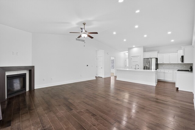 9322 Bellflower Ln, Norwalk, IA 50211 - unfurnished living room featuring ceiling fan, lofted ceiling, a glass covered fireplace, dark wood-type flooring, and recessed lighting