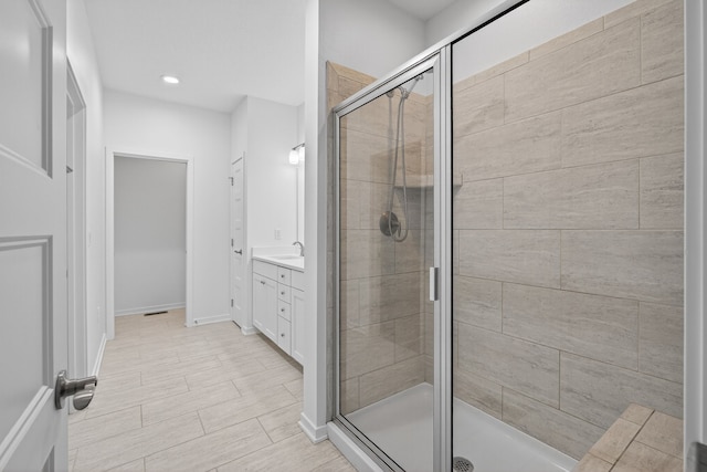 9322 Bellflower Ln, Norwalk, IA 50211 - bathroom featuring vanity, a shower stall, and recessed lighting
