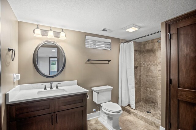1034 66th St, Windsor Heights, IA 50324 - bathroom featuring vanity, a textured ceiling, a tile shower, and tile patterned flooring