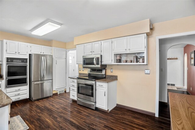 1034 66th St, Windsor Heights, IA 50324 - kitchen featuring stainless steel appliances, a warming drawer, arched walkways, dark wood finished floors, and white cabinetry