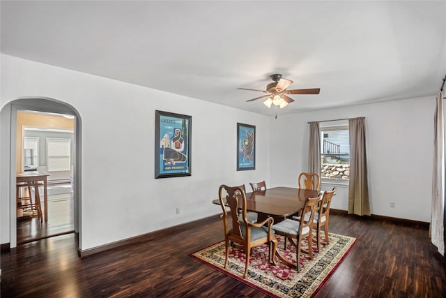 1034 66th St, Windsor Heights, IA 50324 - dining room featuring arched walkways, a ceiling fan, and dark wood finished floors