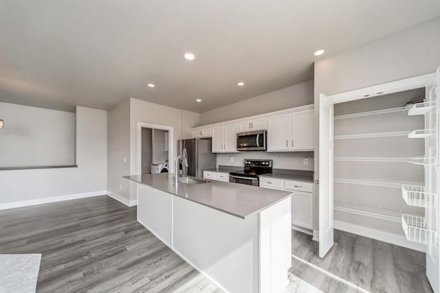 1636 S Redtail Ave, West Des Moines, IA 50265 - kitchen featuring stainless steel appliances, light wood-type flooring, white cabinets, an island with sink, and recessed lighting