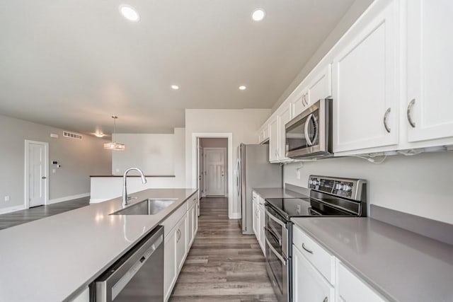1636 S Redtail Ave, West Des Moines, IA 50265 - kitchen with appliances with stainless steel finishes, wood finished floors, white cabinets, decorative light fixtures, and recessed lighting