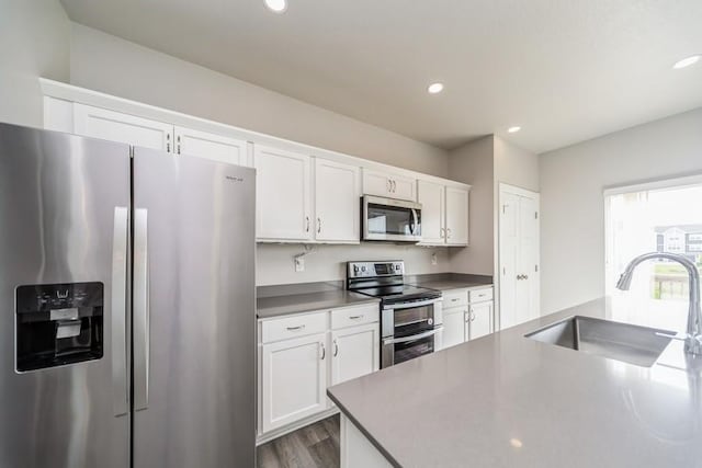 1636 S Redtail Ave, West Des Moines, IA 50265 - kitchen featuring stainless steel appliances, white cabinetry, wood finished floors, and recessed lighting