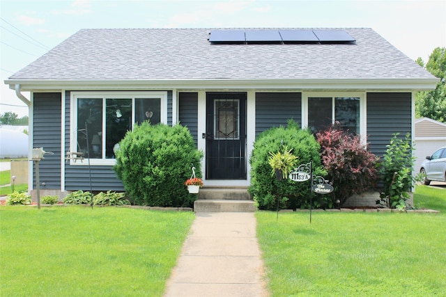 111 S 3rd Ave, Huxley, IA 50124 - bungalow-style home featuring a shingled roof, a front lawn, roof mounted solar panels, and entry steps