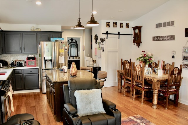111 S 3rd Ave, Huxley, IA 50124 - kitchen with a barn door, appliances with stainless steel finishes, light wood finished floors, a kitchen island, and recessed lighting