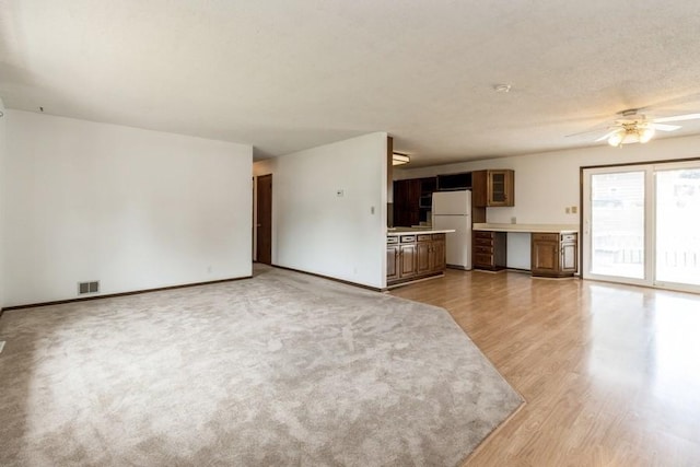 202 Harrison Ct, Baxter, IA 50028 - unfurnished living room with ceiling fan and light wood-type flooring