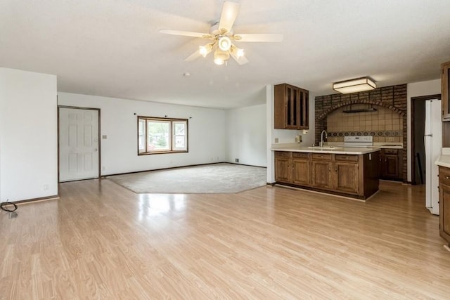 202 Harrison Ct, Baxter, IA 50028 - kitchen with light countertops, light wood-style flooring, a ceiling fan, range, and open floor plan