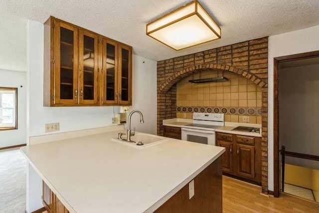 202 Harrison Ct, Baxter, IA 50028 - kitchen with white range with electric stovetop, light countertops, glass insert cabinets, a textured ceiling, and decorative backsplash