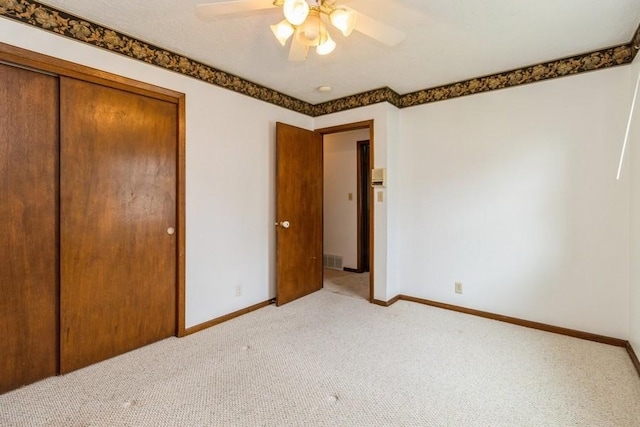 202 Harrison Ct, Baxter, IA 50028 - unfurnished bedroom with light colored carpet, a closet, and a ceiling fan