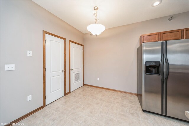1624 NW Prairie Lakes Dr Unit 4, Ankeny, IA 50023 - kitchen featuring stainless steel fridge, brown cabinetry, and decorative light fixtures