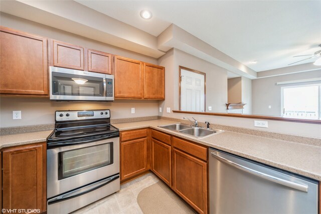 1624 NW Prairie Lakes Dr Unit 4, Ankeny, IA 50023 - kitchen featuring appliances with stainless steel finishes, light countertops, a ceiling fan, light tile patterned floors, and brown cabinetry