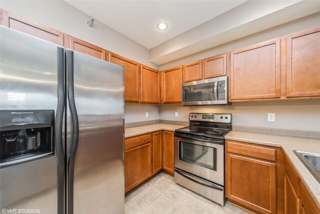 1624 NW Prairie Lakes Dr Unit 4, Ankeny, IA 50023 - kitchen featuring stainless steel appliances, light countertops, recessed lighting, and brown cabinets