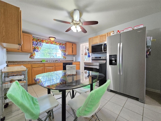 335 Palomino Pkwy, Des Moines, IA 50320 - kitchen with appliances with stainless steel finishes, ceiling fan, light tile patterned floors, and light countertops