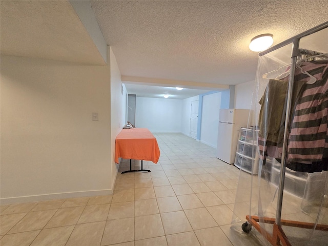 335 Palomino Pkwy, Des Moines, IA 50320 - finished below grade area with freestanding refrigerator, light tile patterned floors, and a textured ceiling