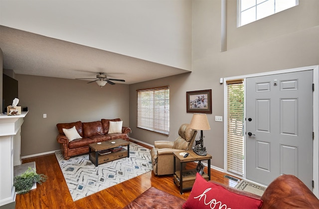 57 SE Meadowlark Ct, Waukee, IA 50263 - living room featuring wood finished floors, a ceiling fan, and a towering ceiling
