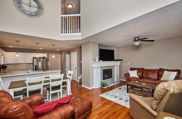 57 SE Meadowlark Ct, Waukee, IA 50263 - living room featuring a ceiling fan, dark wood-style floors, and a fireplace