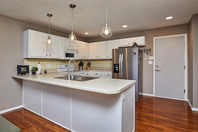 57 SE Meadowlark Ct, Waukee, IA 50263 - kitchen featuring white appliances, a peninsula, light countertops, backsplash, and recessed lighting