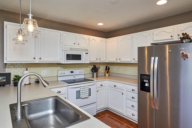 57 SE Meadowlark Ct, Waukee, IA 50263 - kitchen with white appliances, white cabinets, dark wood-type flooring, hanging light fixtures, and recessed lighting