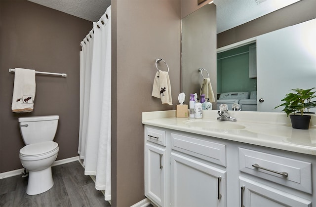 57 SE Meadowlark Ct, Waukee, IA 50263 - bathroom with vanity, wood finished floors, a textured ceiling, washing machine and clothes dryer, and a shower with curtain