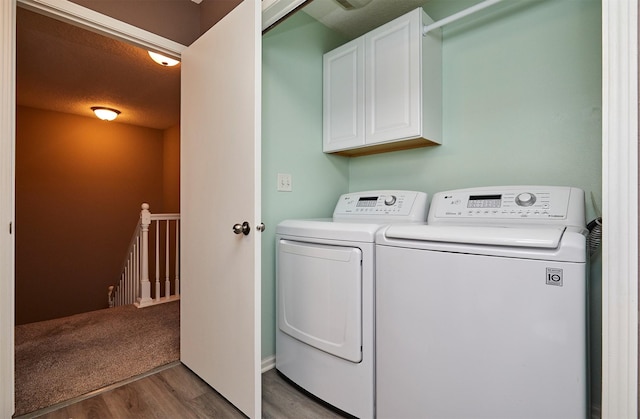 57 SE Meadowlark Ct, Waukee, IA 50263 - washroom with washer and clothes dryer, cabinet space, and wood finished floors