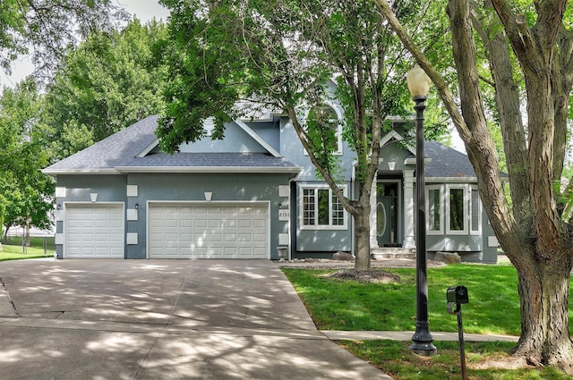 8151 Chambery Blvd, Johnston, IA 50131 - view of front of property with a shingled roof, an attached garage, stucco siding, and concrete driveway