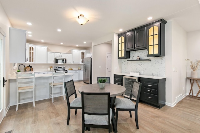 8151 Chambery Blvd, Johnston, IA 50131 - dining space featuring wine cooler, light wood-style flooring, bar with sink, and recessed lighting