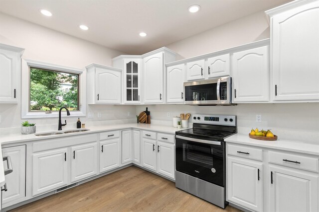 8151 Chambery Blvd, Johnston, IA 50131 - kitchen featuring appliances with stainless steel finishes, white cabinetry, light countertops, recessed lighting, and light wood finished floors
