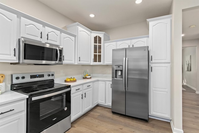 8151 Chambery Blvd, Johnston, IA 50131 - kitchen featuring stainless steel appliances, light wood-style flooring, white cabinetry, glass insert cabinets, and recessed lighting