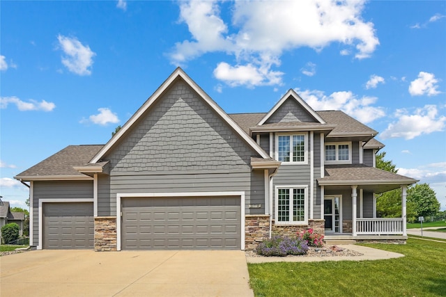 4108 158th Cir, Urbandale, IA 50323 - craftsman-style home with covered porch, a garage, driveway, stone siding, and a front yard