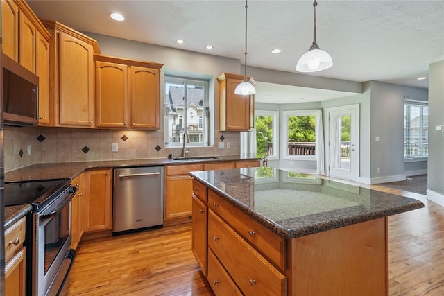 4108 158th Cir, Urbandale, IA 50323 - kitchen featuring stainless steel appliances, light wood-style flooring, decorative backsplash, a center island, and recessed lighting