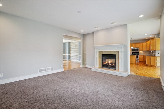 4108 158th Cir, Urbandale, IA 50323 - unfurnished living room with light carpet, recessed lighting, and a tile fireplace