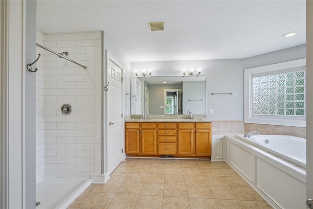 4108 158th Cir, Urbandale, IA 50323 - bathroom featuring a tile shower, double vanity, a garden tub, a textured ceiling, and a chandelier