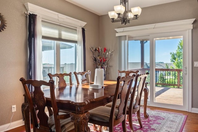 655 NE Dellwood Dr, Waukee, IA 50263 - dining room with a chandelier, wood finished floors, and a textured wall