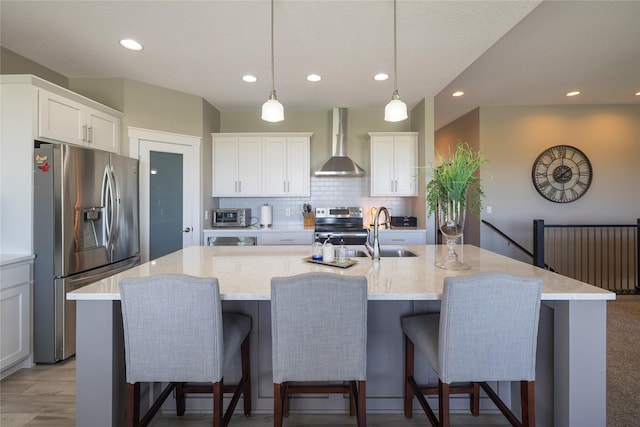 3210 NE 17th St, Ankeny, IA 50021 - kitchen featuring wall chimney exhaust hood, appliances with stainless steel finishes, backsplash, recessed lighting, and a large island with sink