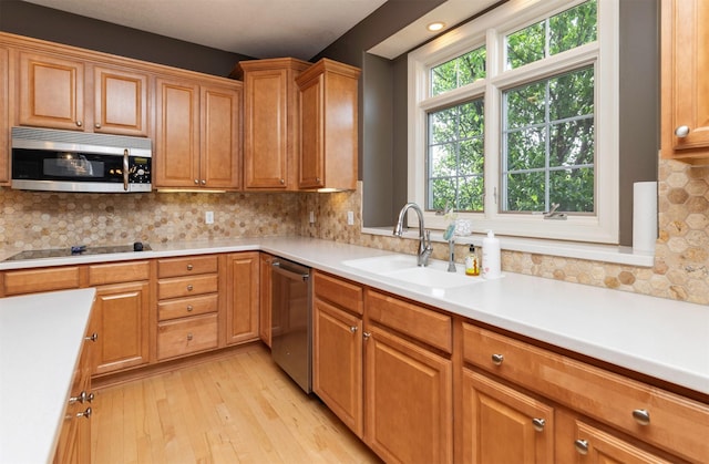 12602 Winston Ave, Urbandale, IA 50323 - kitchen with appliances with stainless steel finishes, light wood-style floors, light countertops, and tasteful backsplash